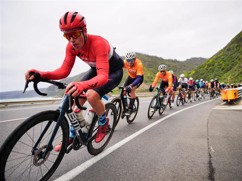 A group of cyclists race along the Great Ocean Road