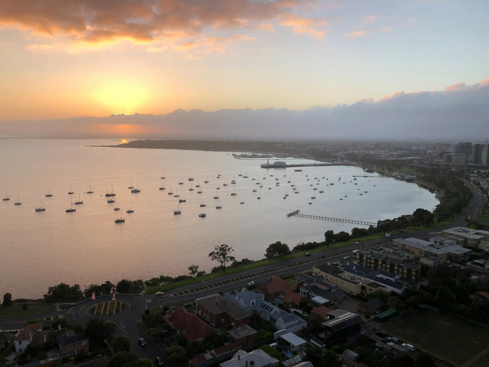 Boats in the Bay as the sun rises over the clouds in the dawn light.