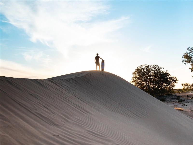 Man sandboarding at sunset at Perry Sandhills near Wentworth