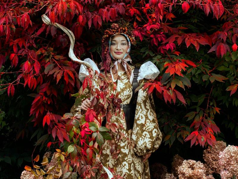 Flowers Vasette Melbourne Florist in front of beautiful blooming tree with vibrant red leaves.